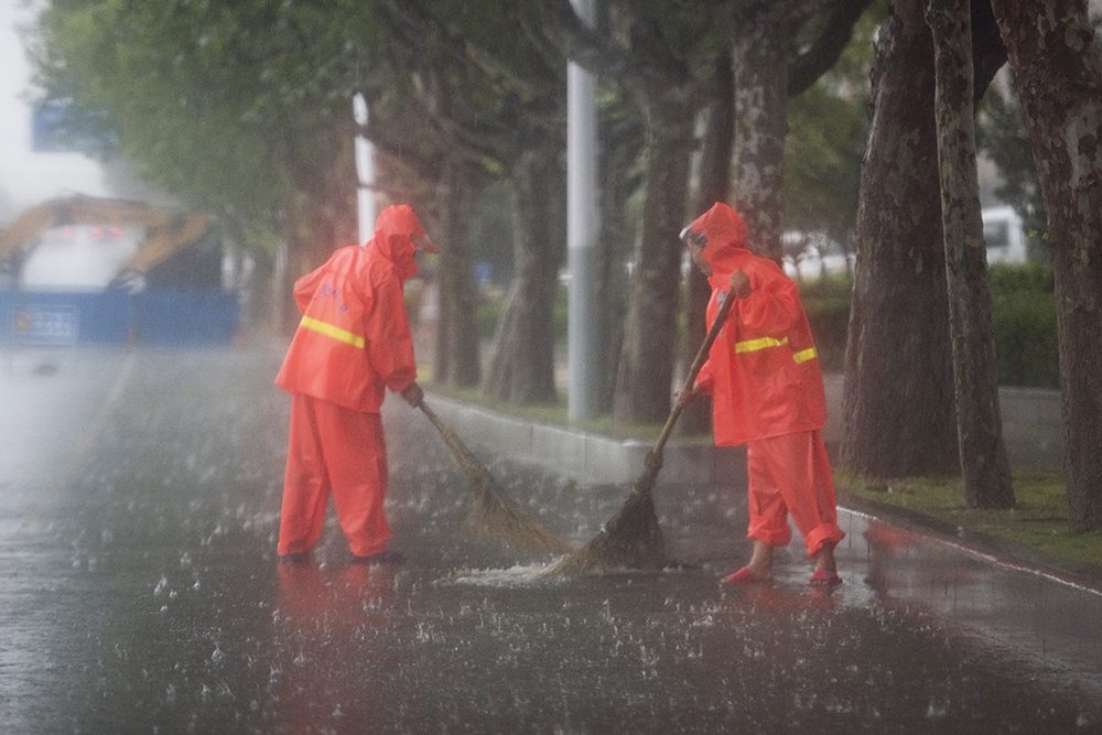 当看到环卫工人冒着大雨双手捡起路面上的脏污垃圾