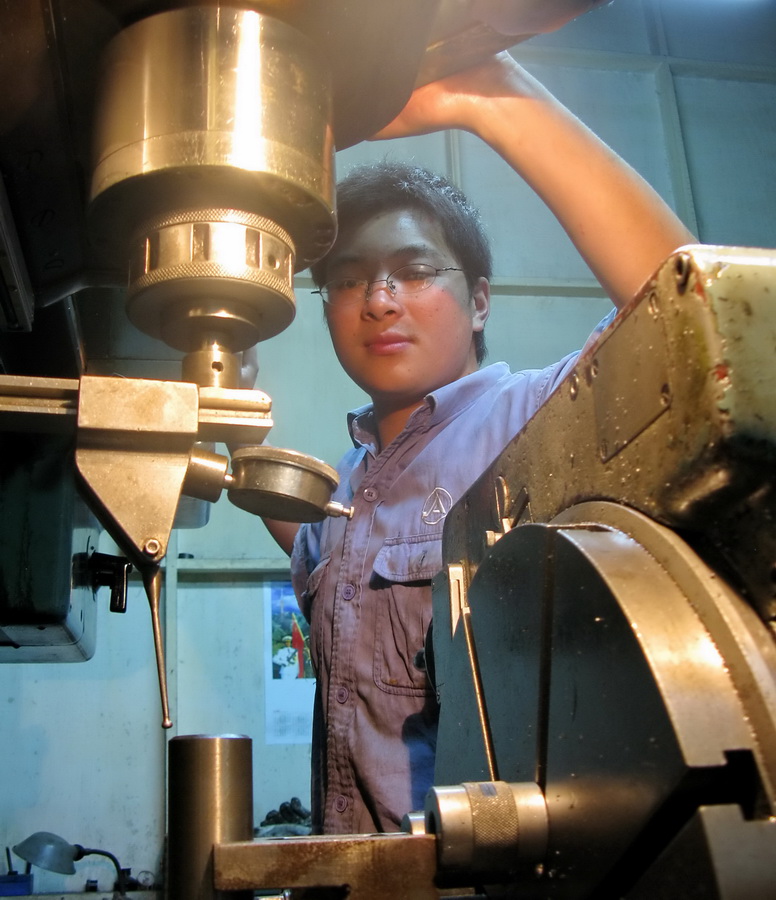 测试_ 一镗床工用千分表精心测试找准工件中心,再进行镗孔以确保产品