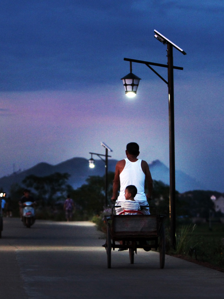 2017年9月江西乐平市镇桥镇  傍晚太阳能路灯下回家的村民