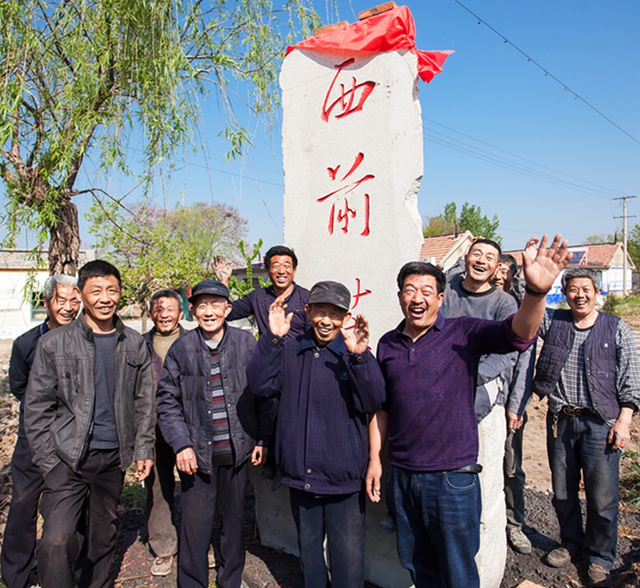 平度西前庄的村头立起了村碑,村民高兴的集体合影.