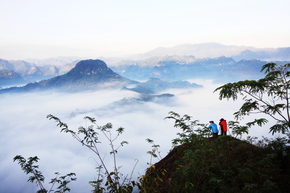 一对情侣在云海漫漫的斗笠山拍照.