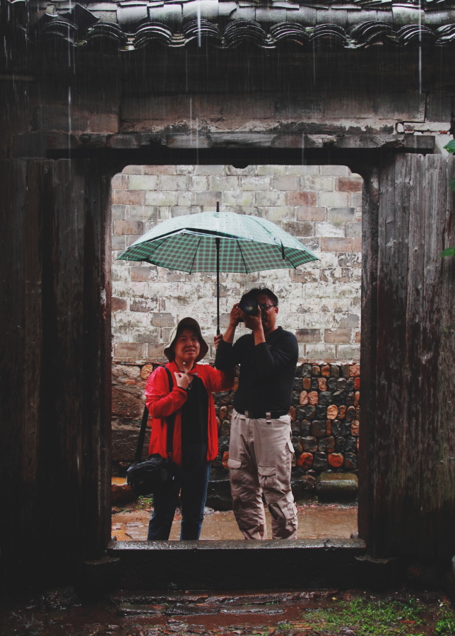大雨如注,却挡不住这对老夫妻爱好摄影的兴致,妇唱夫随,配合默契,其情