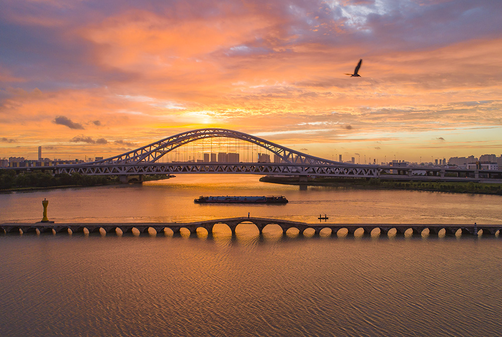 简要说明:朝霞下的京杭大运河,千年宝带桥与新建的斜港大桥交相辉映