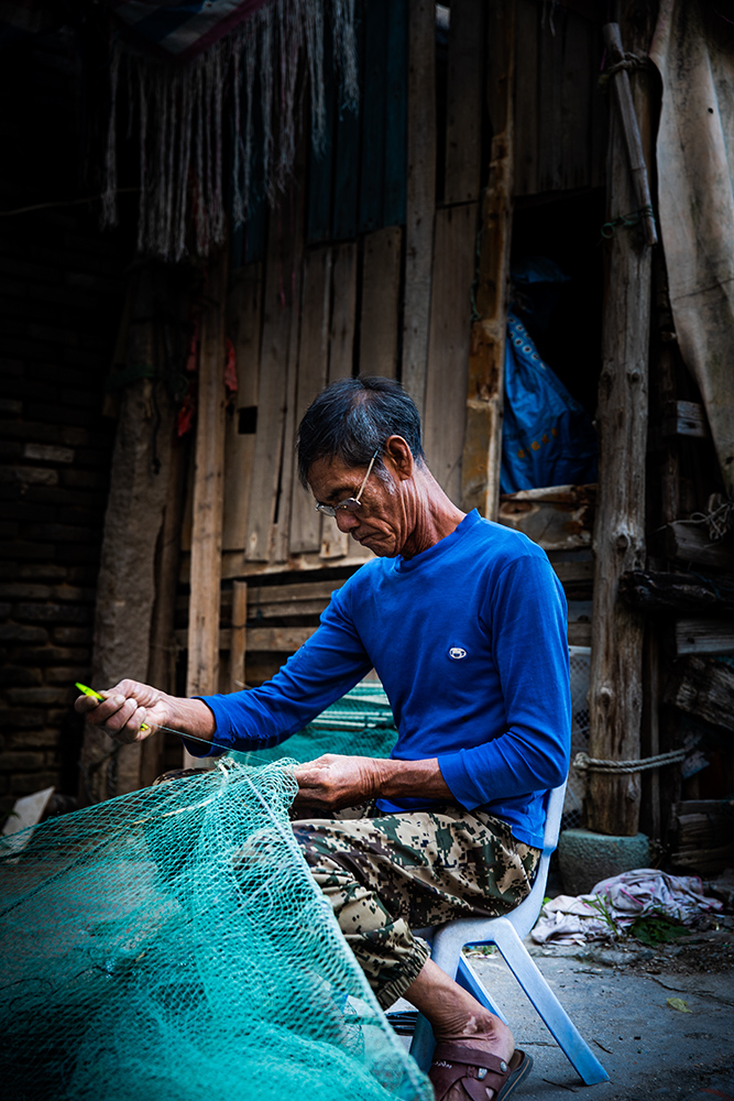 《补渔网的老渔工》组图