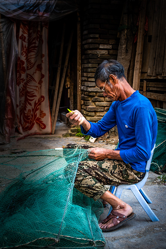 《补渔网的老渔工》组图