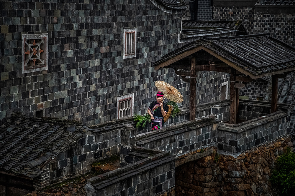 傍晚,天渐渐黑了,一位畲族女才采着草药归来!