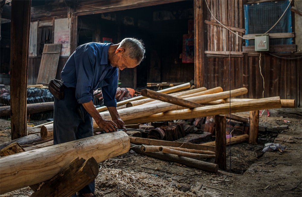 老木匠正在用传统手艺修复老屋.