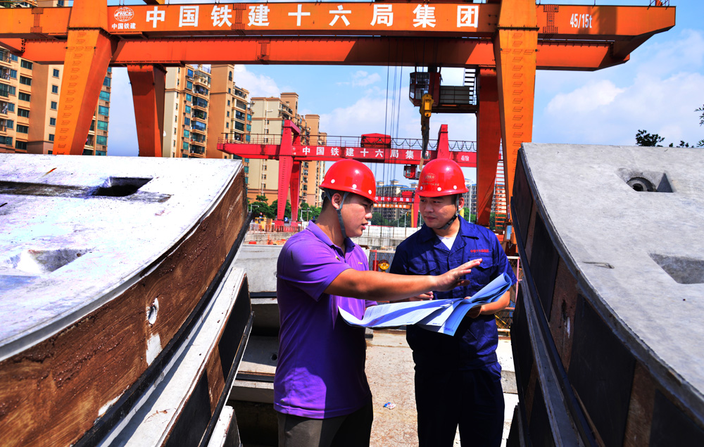 九号线马鞍山公园站广东基础公司施工人员在工地查看图纸