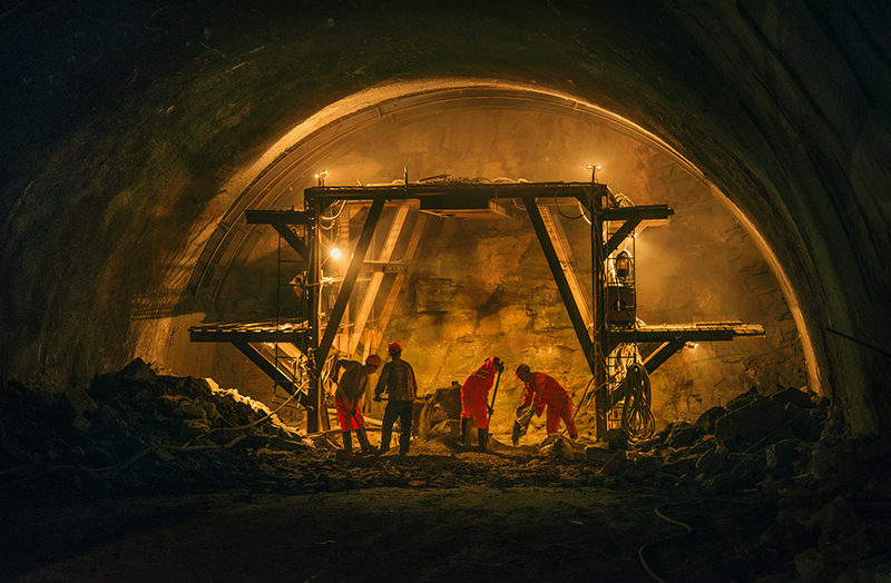 一高速公路隧道口施工现场,筑路工人们正在挑灯夜战,为高速公路建设