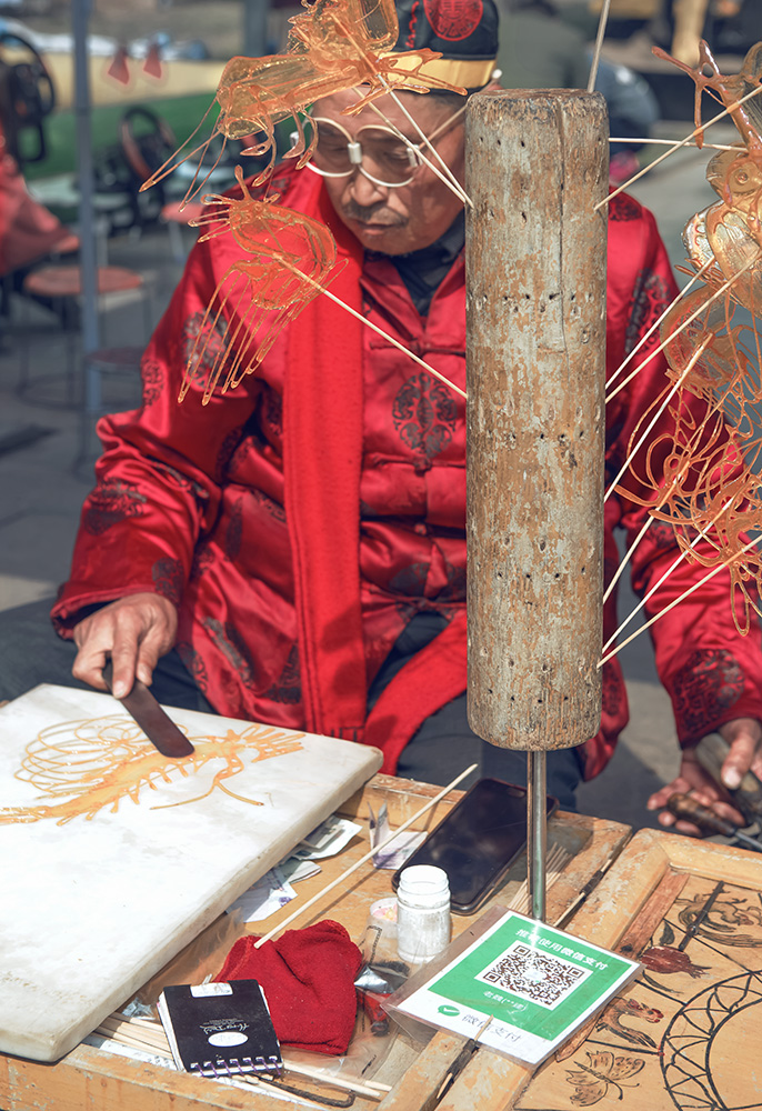 28-4 民间非遗 - 糖作画 2018年3月2日洛阳关林庙里制作糖画的老人.