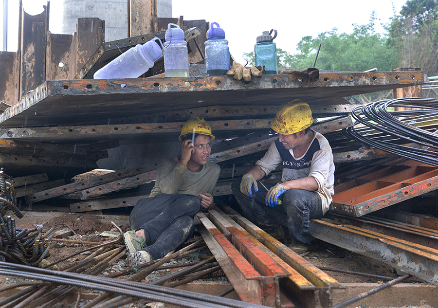 《避雨》广东省揭阳市在建中的"潮汕梅高铁"工人在工作中遇雨,他们