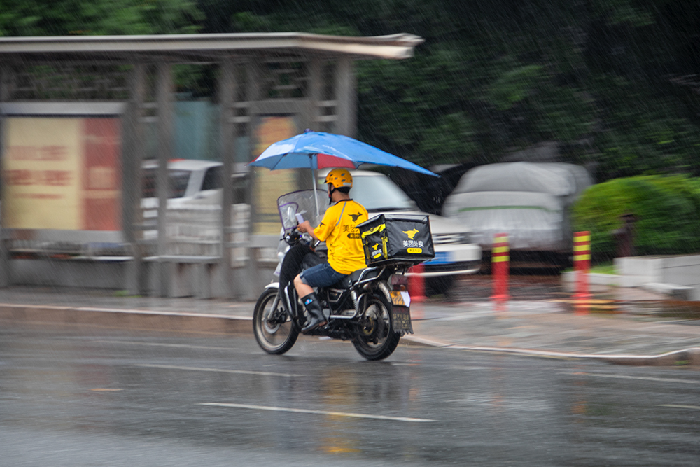 2019年5月摄于福建三明,一名美团外卖的小哥冒雨送餐.