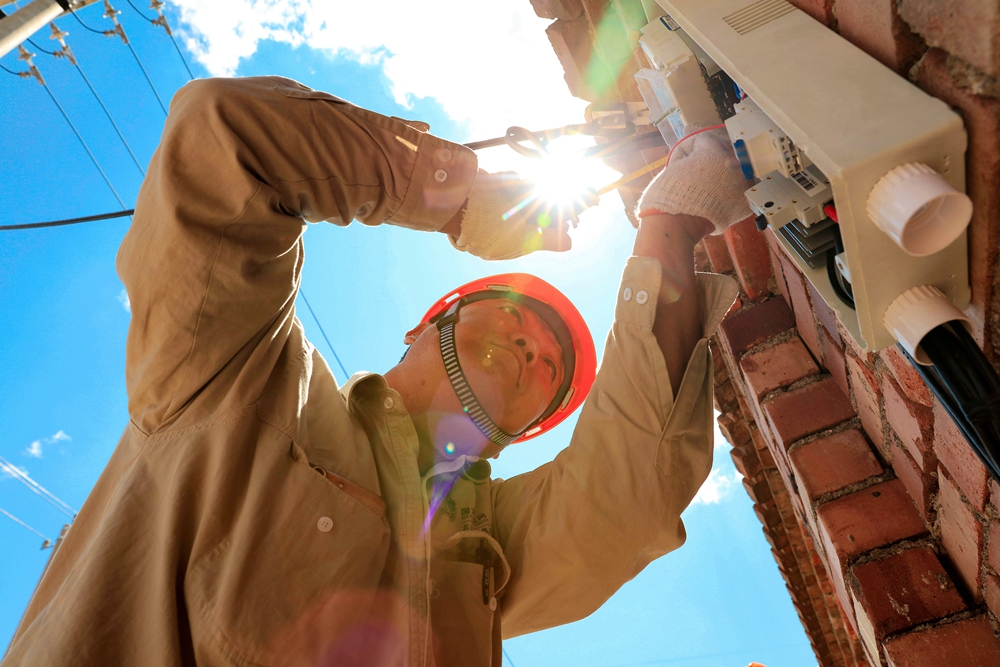 用电工人在烈日下安装电表