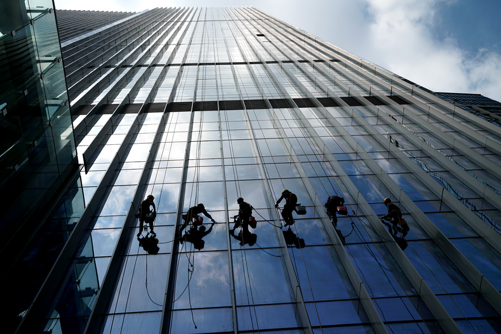 工人在炎热的太阳中清洗大楼幕墙