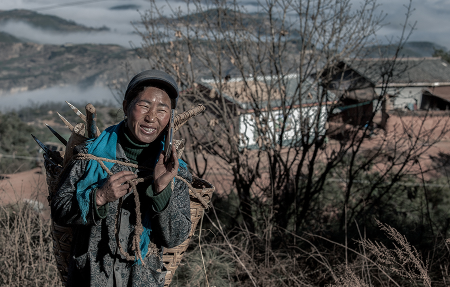大凉山的彝族农民,在劳动的时候接到了手机,家里来了客人,让她赶紧