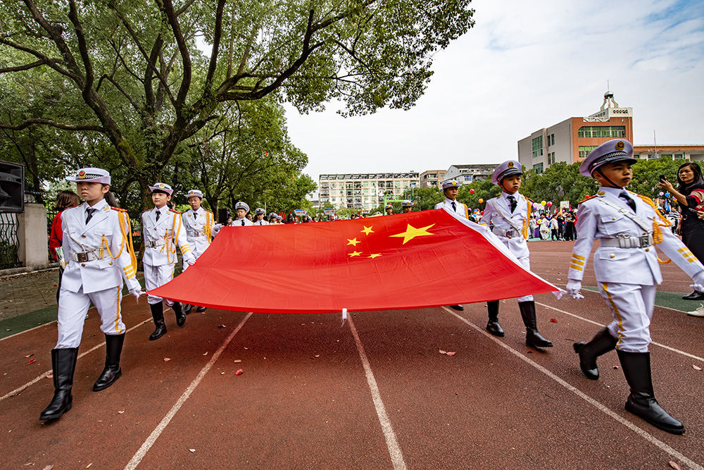 小护旗手们手拿着国旗,迈着矫健的步伐走向旗