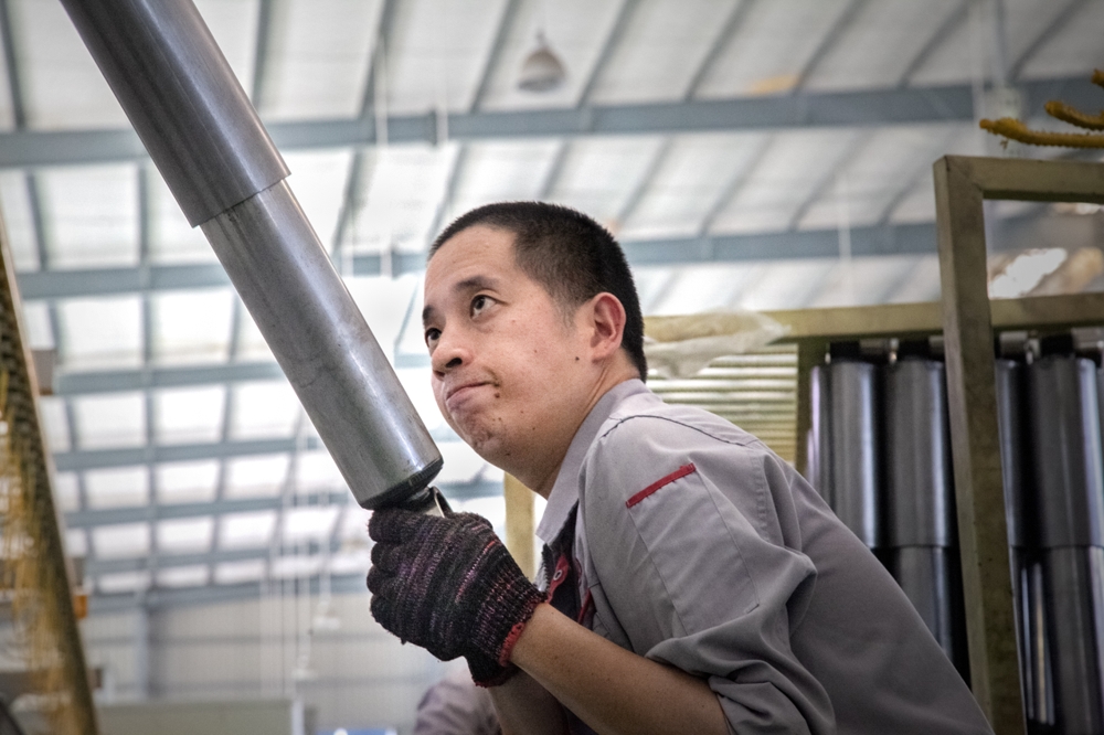 《擎天柱》2018年9月摄于福建省南安市,一名机械厂的工人正在车间劳作