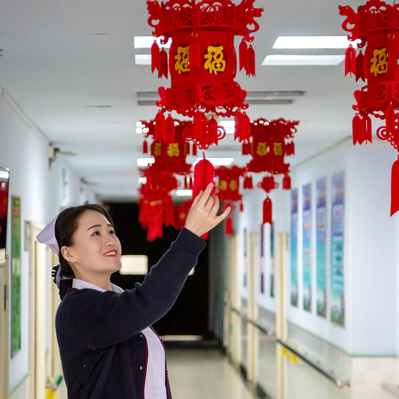 新年的病房走廊里年轻护士整理灯笼