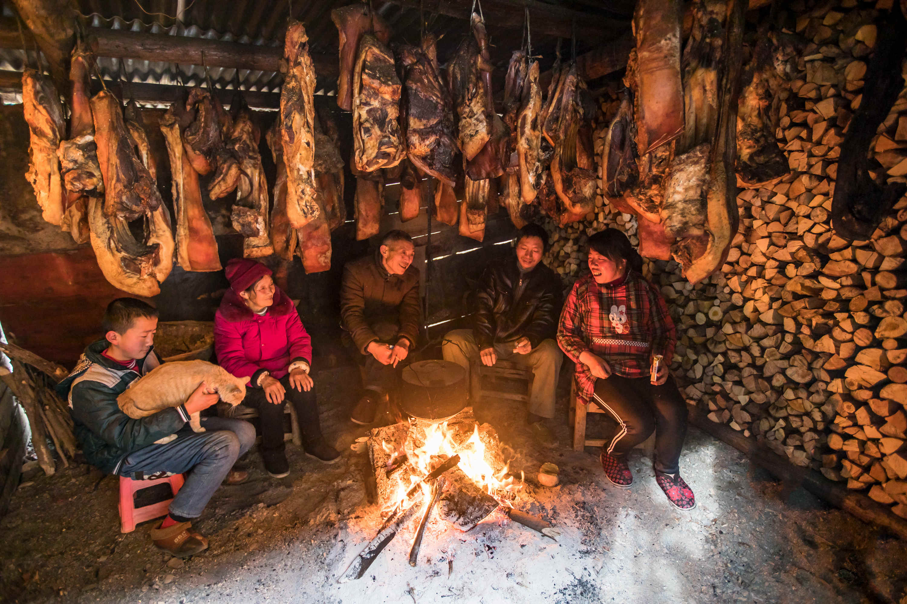 县柳林乡墨池村村民戴志成一家围坐在挂满腊肉的火炉周围,烤火唠嗑