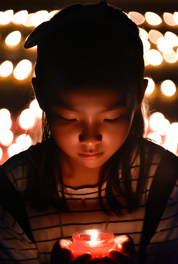 小女孩手捧烛灯正在祈福