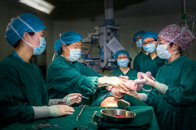 妇产科的手术台,一群医生正在为手术台上的病人而忙碌.