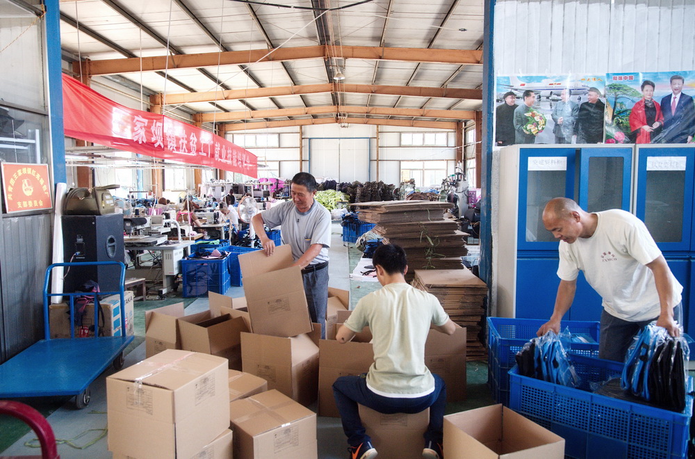 2-家门口的"扶贫车间"(组图):王家坝镇红亮箱包厂产品打包中.jpg.jpg