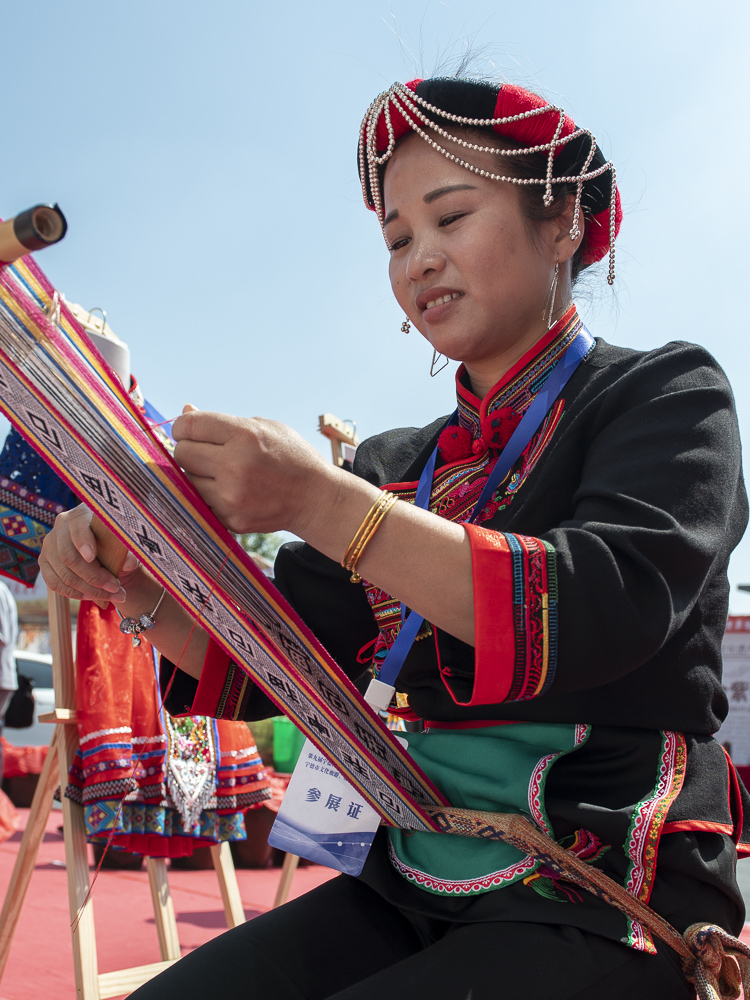 2019年9月摄于福建省周宁县,图为畲族姑娘在旅游项目推介会上演示衣饰