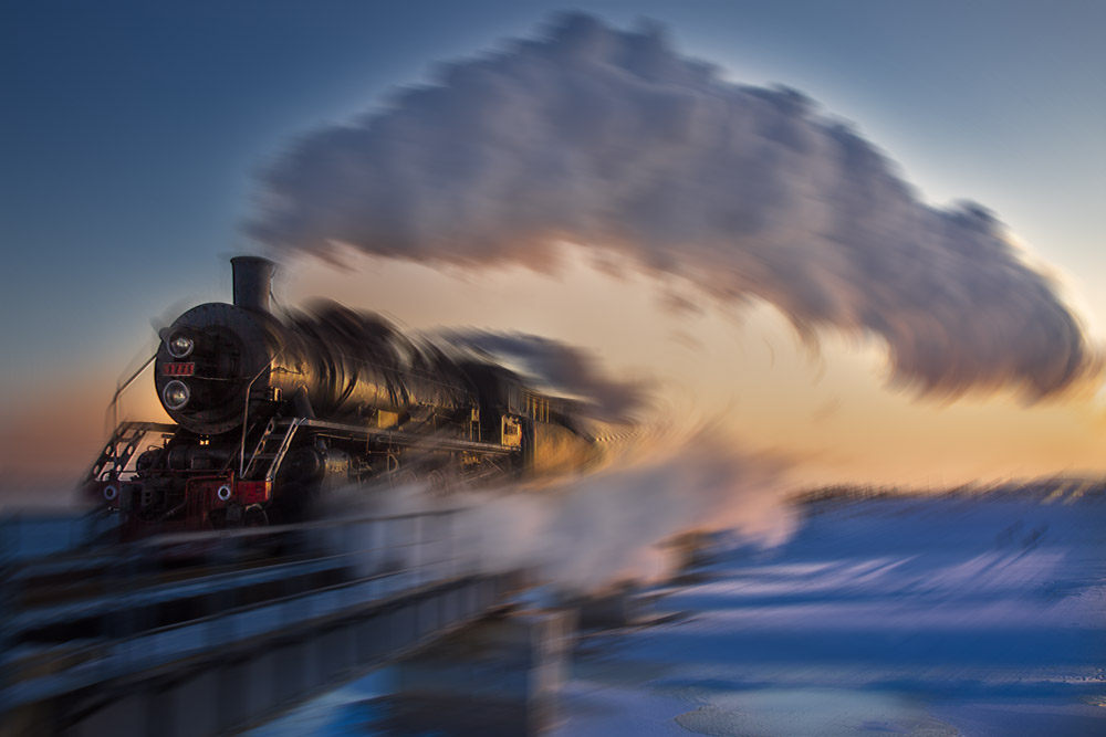 一列风驶电掣蒸汽什么火车从晨曦映射的雪地呼啸而过,强大的视