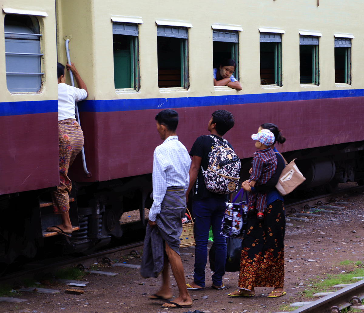 在缅甸曼德勒火车站,乘客彬彬有礼地排队上车去远方.