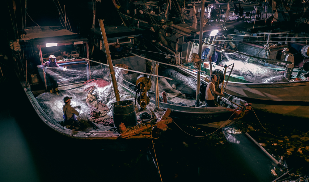 静静的夜,海浪轻轻地拍打着船舷,渔民们灯光下打理捕鱼工具2013-9-27