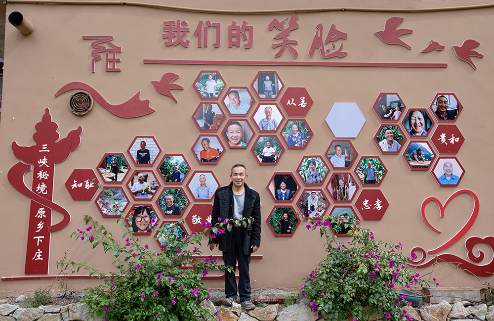 2020年10月21日获奖后毛相林与村里的笑脸墙合影